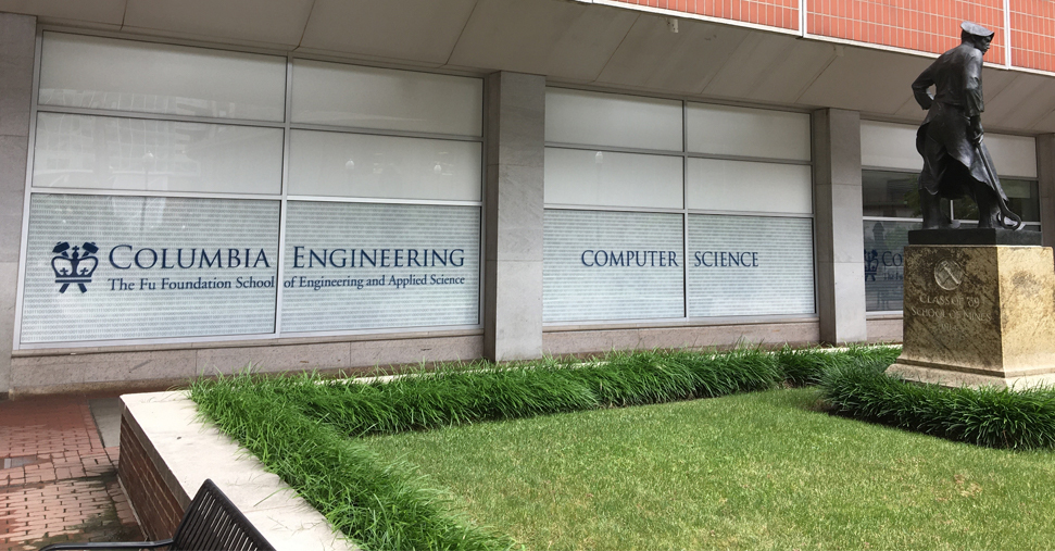 Windows that say Columbia Engineering and Computer Science on them with a statue and small lawn in front