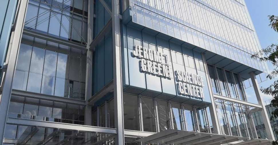 A view of the white Jerome L. Greene Science Center sign on the blue facade of the building