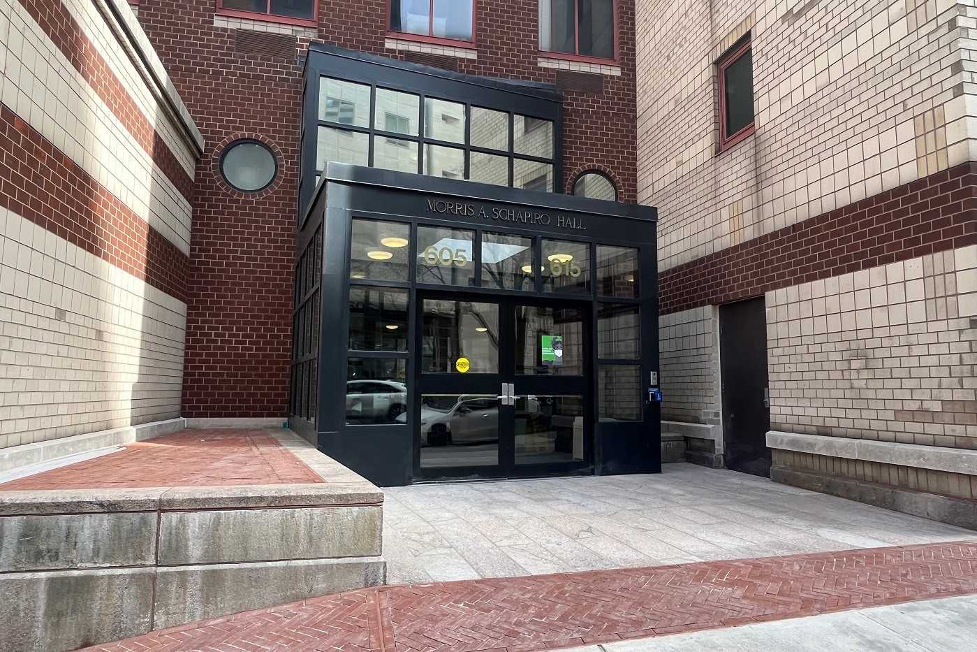 The building entrance to Schapiro Hall, featuring new brick and stone pavers at the entrance pathway.