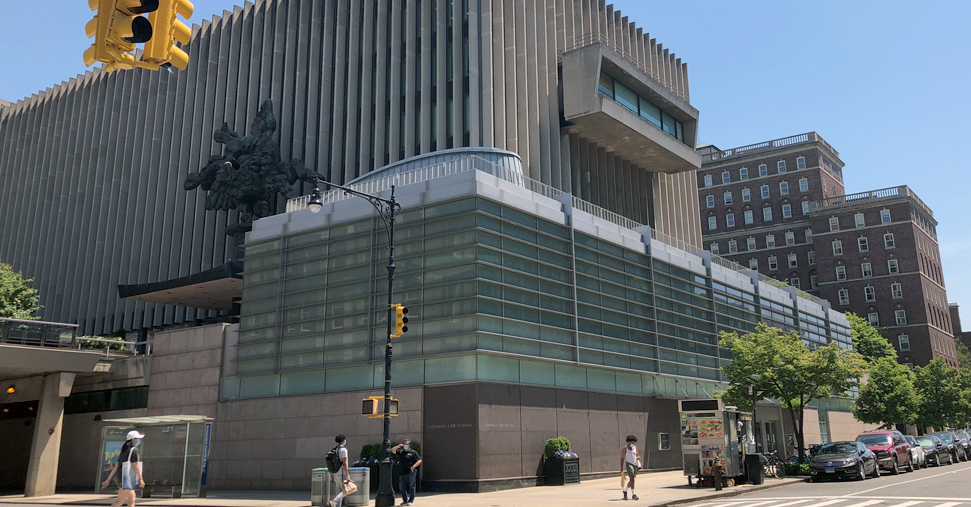 An exterior shot of Jerome Greene Hall from across the street at the College Walk entrance on a sunny cloudless day