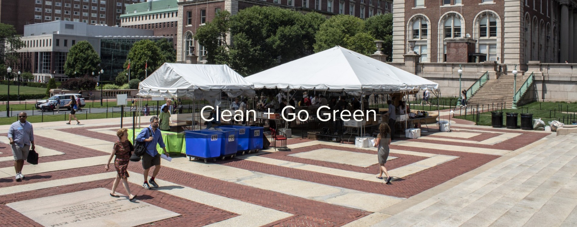 People walk by two large white tents on Low Plaza that are full of donations of books and other household goods
