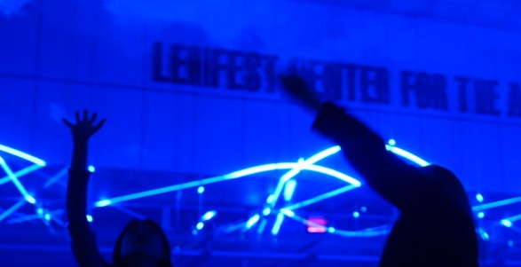 People pointing up at blue lasers above them with Lenfest Center for the Arts behind them