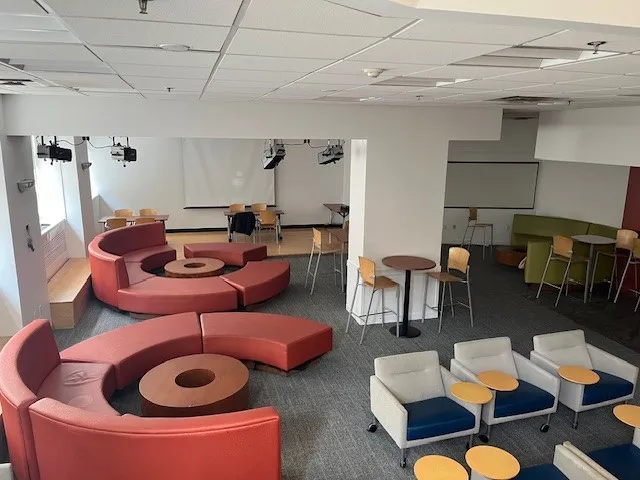 A view of the Carman Hall basement lounge with new carpeting, paint, and lighting.