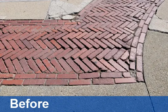 A "before photo" of the plaza, with broken and uneven brick and cracked concrete. 