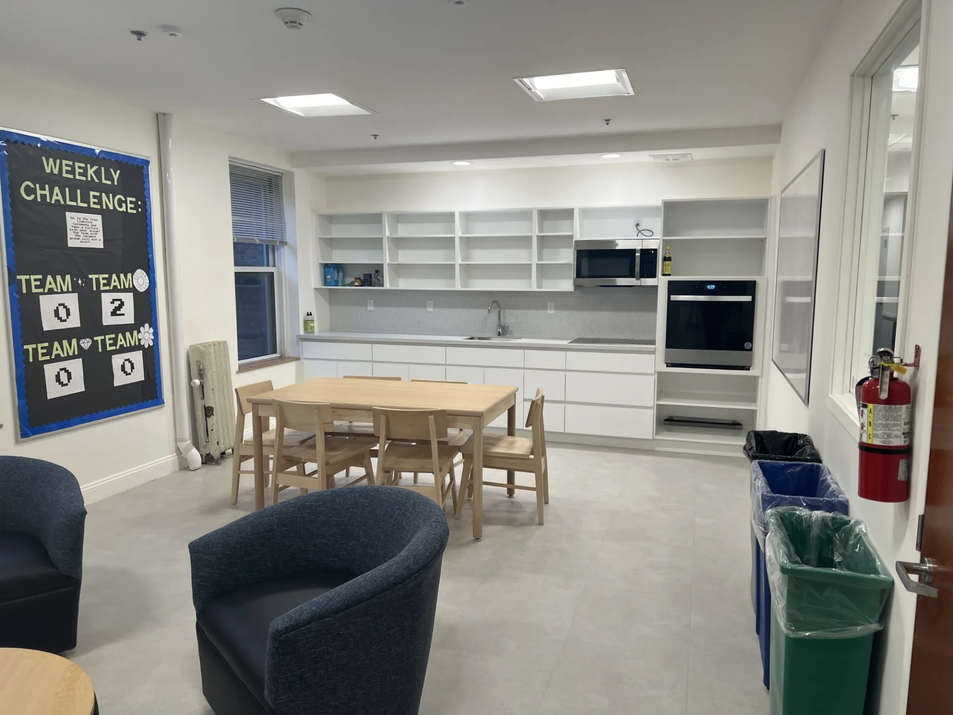 A refreshed kitchen and lounge space in McBain Hall, featuring white cabinetry, a new electric oven and stovetop.